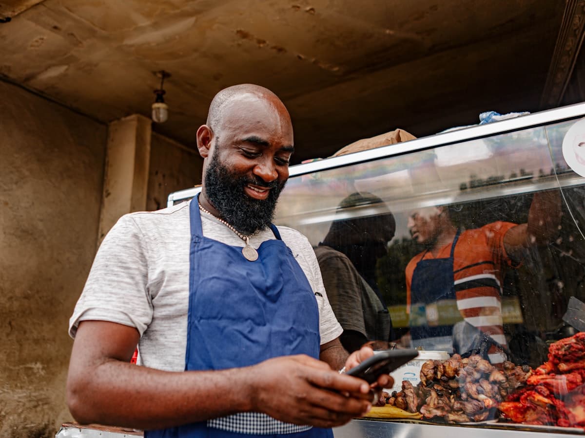 A vendor checking his phone at his stall