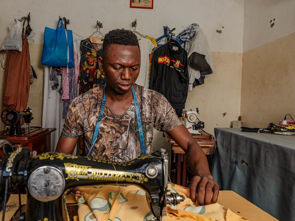 A tailor working at a sewing machine in his workshop