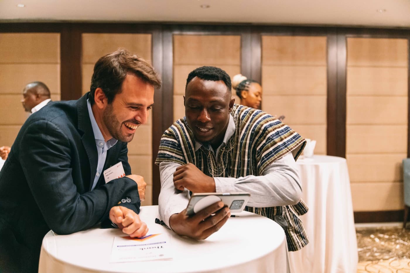 Two delegates going through figures on a tablet at a partnership event